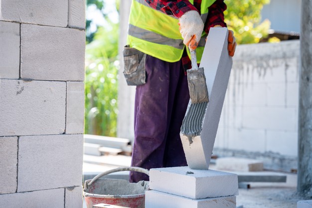 bricklayer builder using cement mortar put lightweight bricks construction site 61243 1076