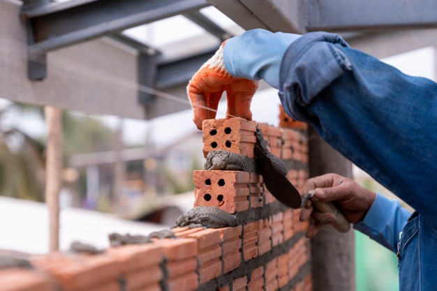 bricklayer worker installing brick masonry wall with trowel putty knife construction site 61243 1165